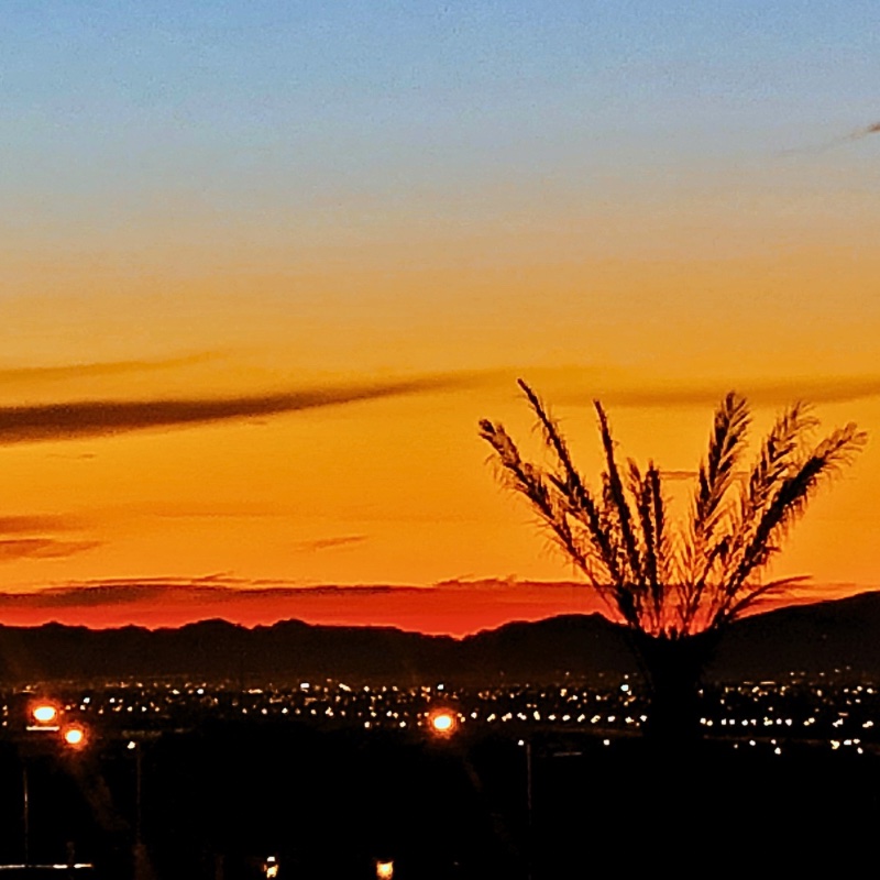 Las Vegas sunrise from a balcony with vibrant orange and blue tones