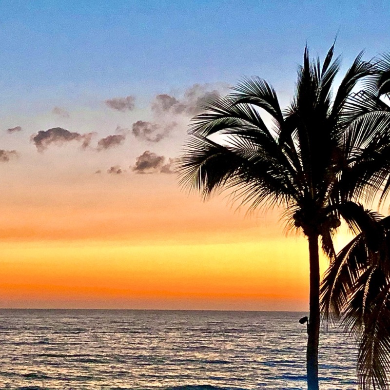 Golden hues melt into deep orange over Playa Los Muertos, as Puerto Vallarta’s beach town glows under the fading sunlight.