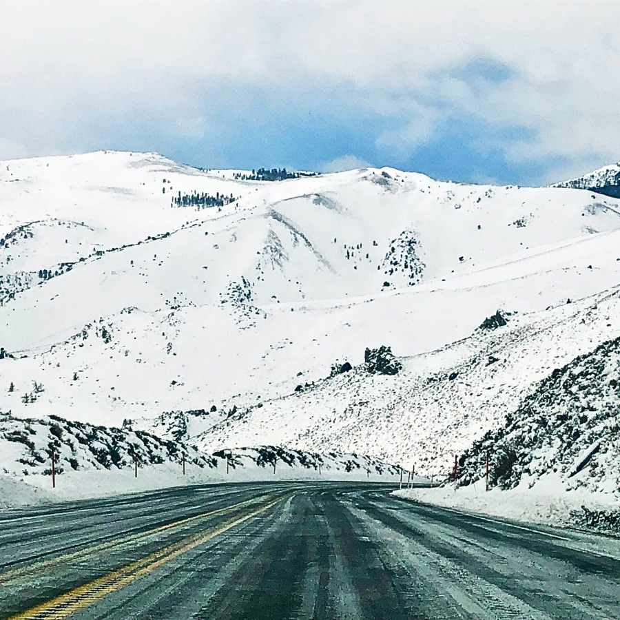 The road to Reno blanketed in white, with distant mountains fading into a winter haze.