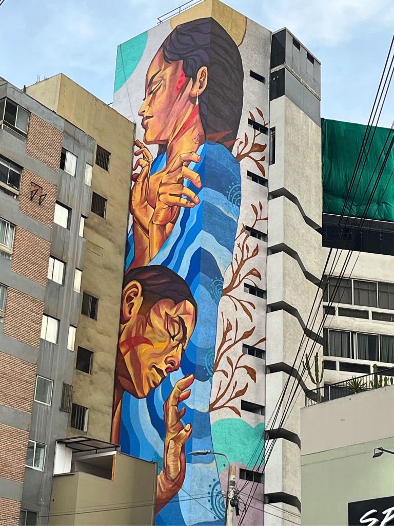 Urban art in Lima showcases a dreamlike scene where human faces, symbols, and organic shapes blend together, creating an atmosphere of mystery and energy.