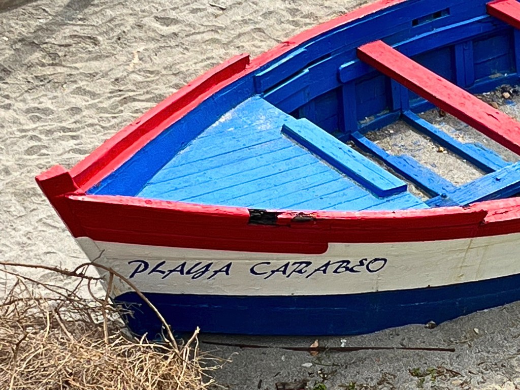 Close-up of a colorful boat on Playa Carabeo in Nerja, Spain, with vibrant Red and blue colors.