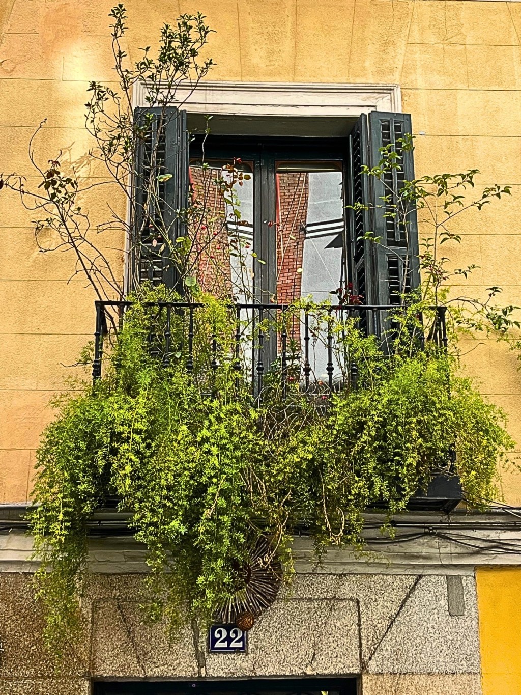 A historic building in Madrid's Embajadores neighborhood with ornate balconies and a warm-colored façade.​