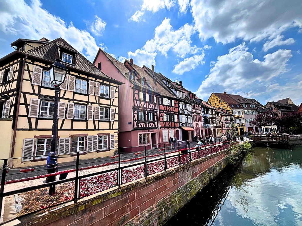 Colorful half-timbered houses reflected in a canal along Rue des Tanneurs in Colmar, Alsace, France.