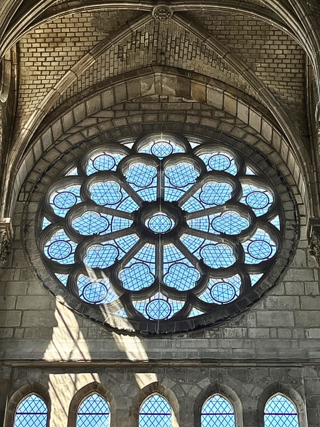Close-up of the Gothic rose window at Basilique Saint-Nicolas in Nantes, France, featuring intricate stained glass and stone tracery.