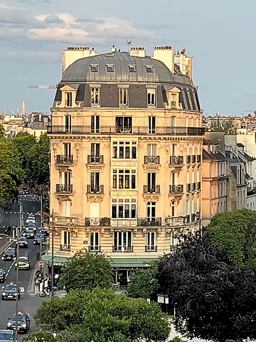 Haussmannian building on Quai Saint-Michel in Paris, seen from Île de la Cité, with slate mansard roof, wrought-iron balconies, and golden-hour light reflecting on cream stone façade.