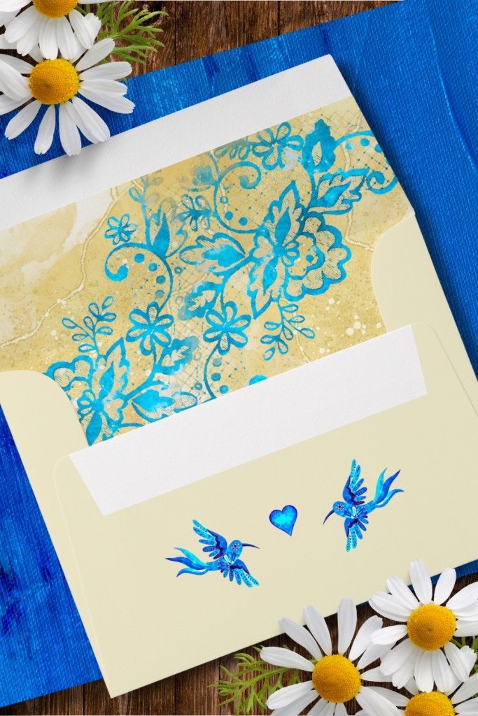 Elegant wedding envelope from the Blue Hummingbird Baroque Wedding Suite featuring two watercolor hummingbirds and a cobalt heart on the flap, with a golden floral lace liner in turquoise and blue hues. Perfect for luxury Mexican-inspired or destination wedding stationery.
