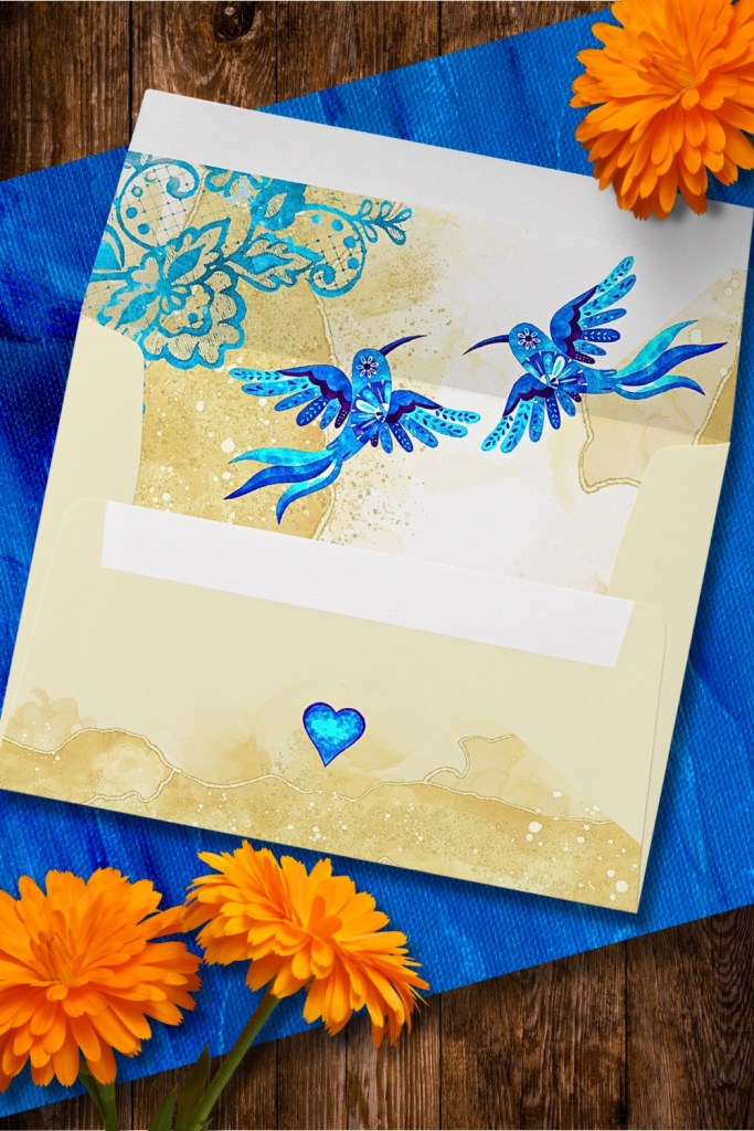 Elegant wedding envelope design featuring two hand-painted blue hummingbirds and a luminous cobalt heart over a parchment gold Baroque floral background.