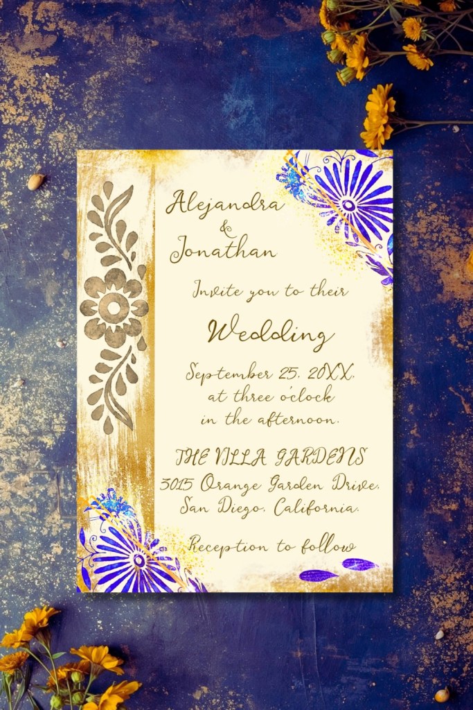 Blue and gold Talavera wedding invitation with floral folk art motifs and soft gold accents, styled on a textured indigo background with marigold flowers
